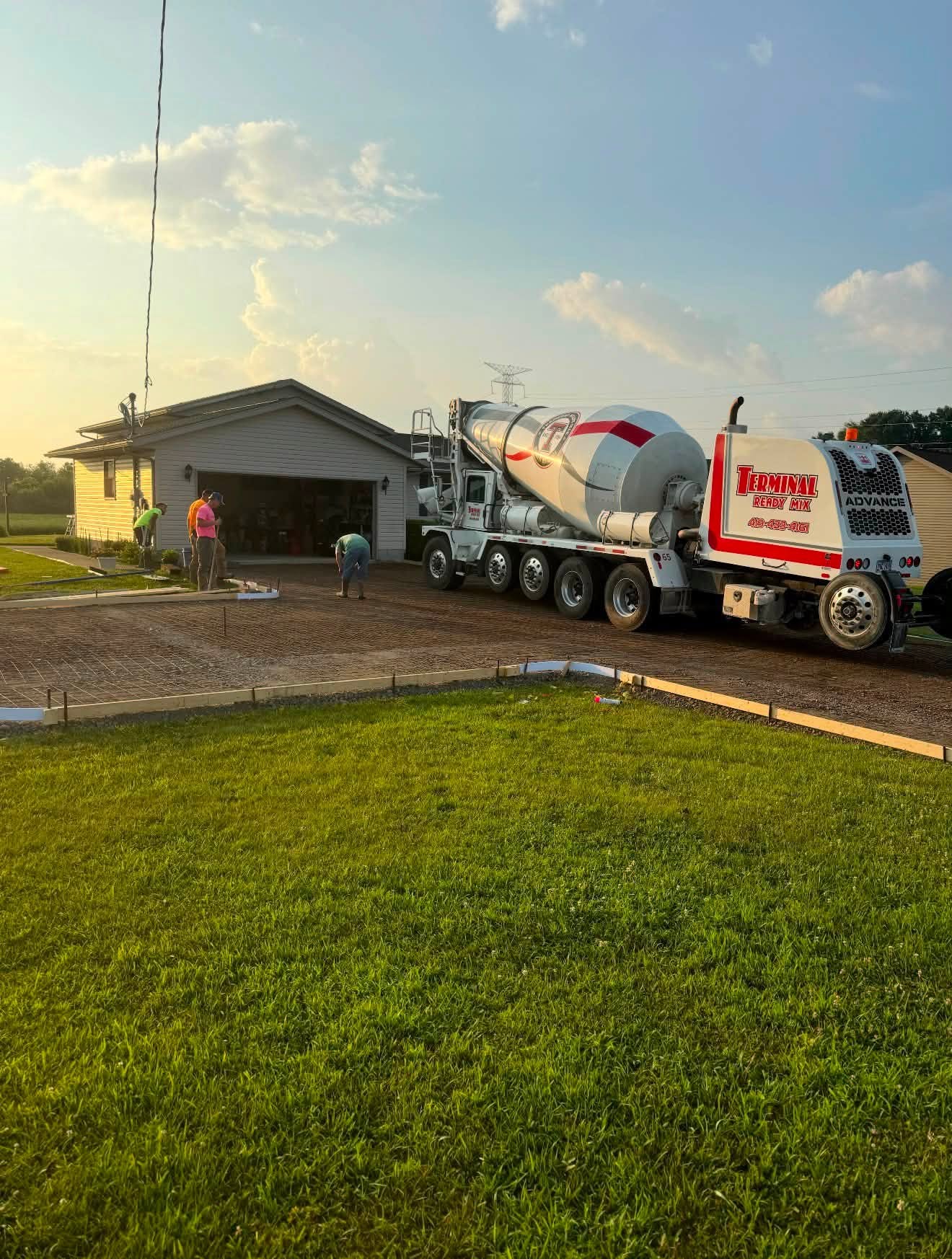Ready-mix truck and crew pouring a large driveway
