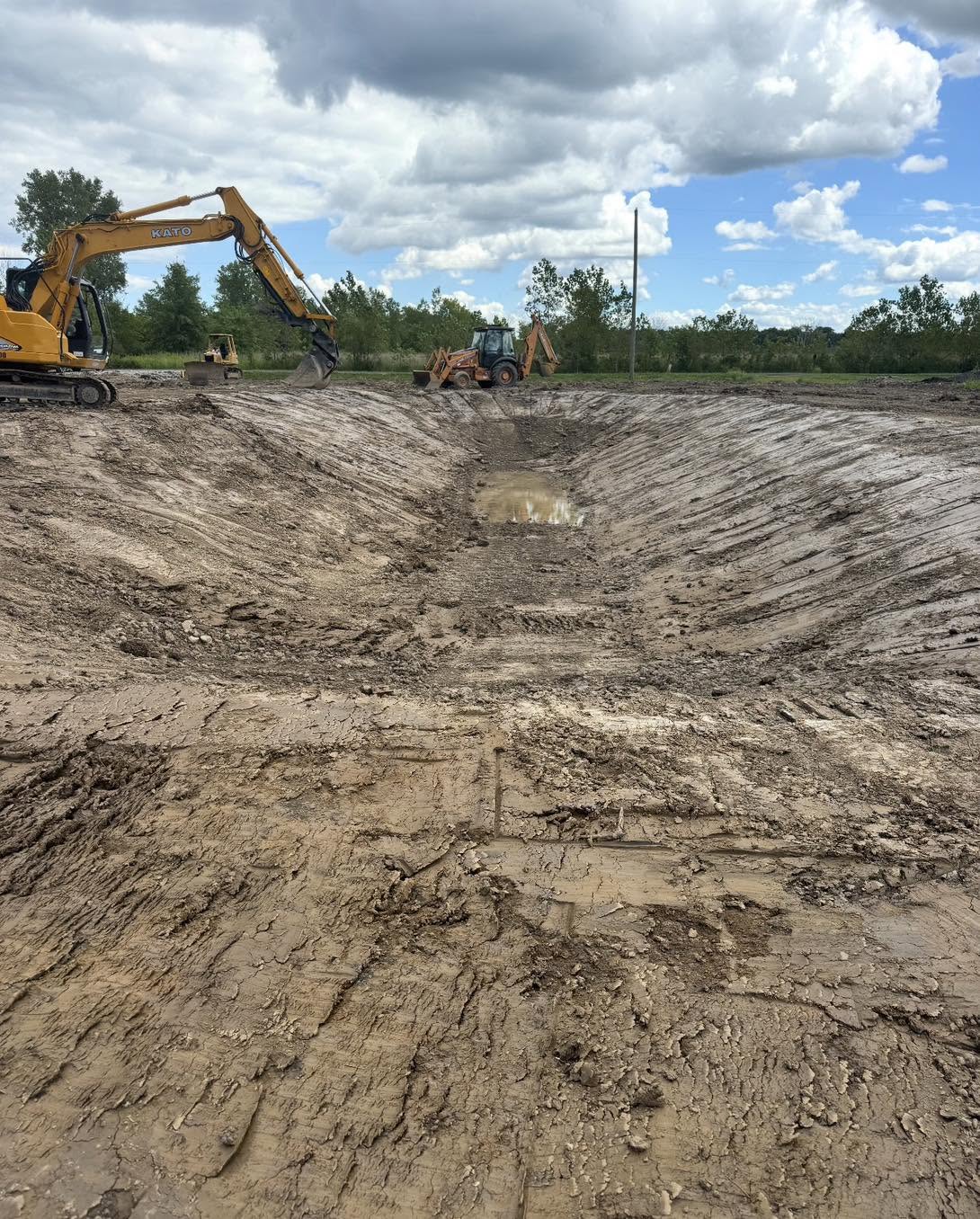 Excavators shaping a new pond